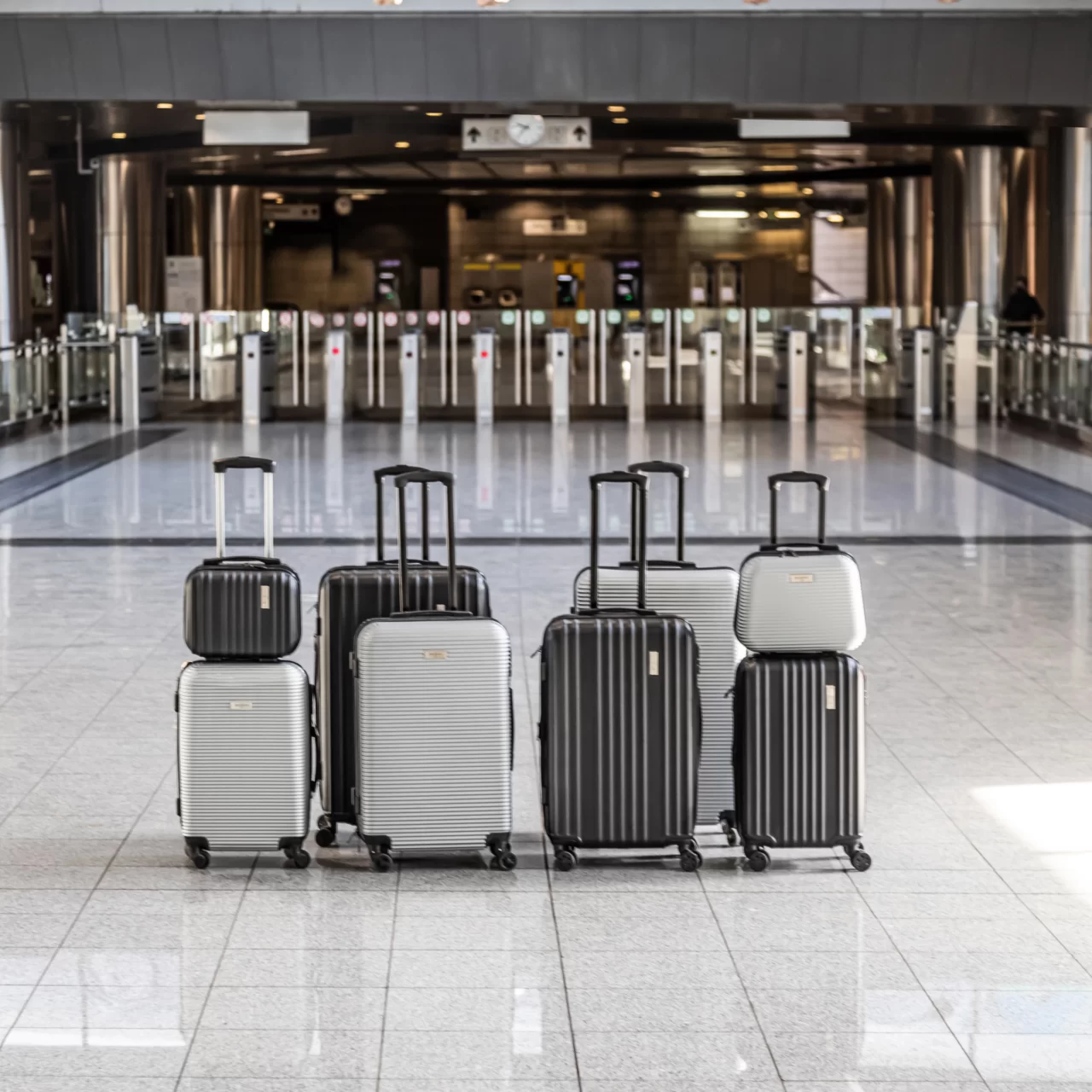οχτώ μαύρες και ασημένιες σε διαφορετικά μεγέθη βαλίτσες σε αστικό περιβάλλον
