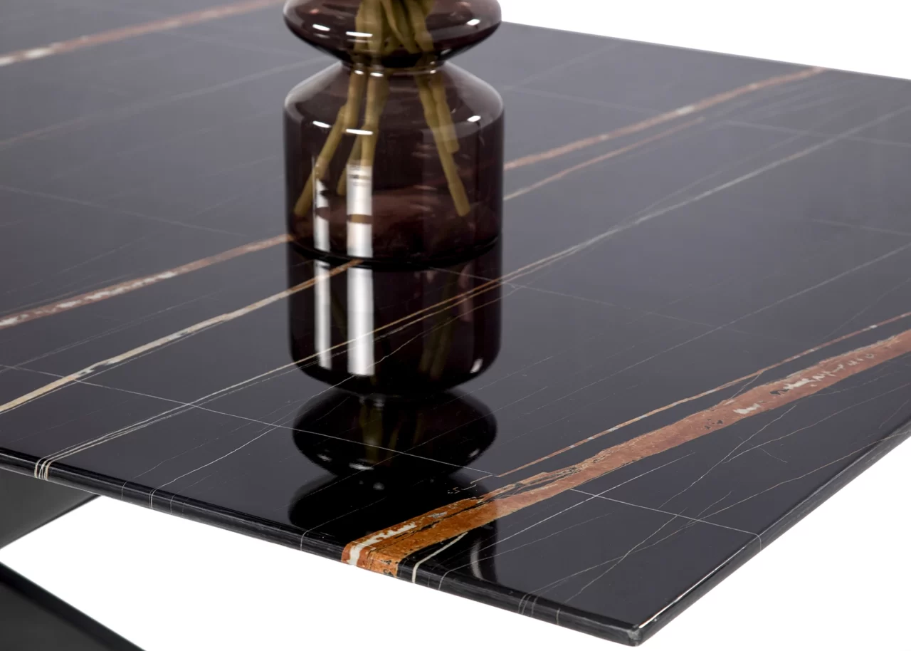 a close up shot of a black marbled glass table with a vase on top of it